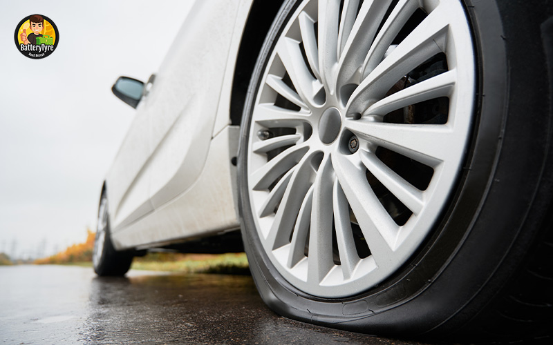 Car with a flat tire on the road.