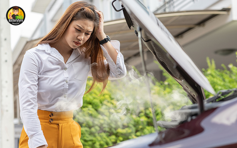 Woman stressed by smoking car engine.