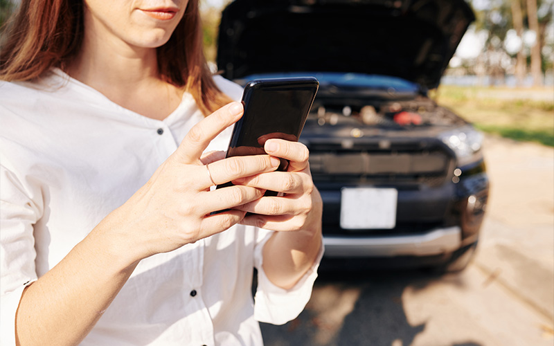 Person calling for assistance with a broken-down car.